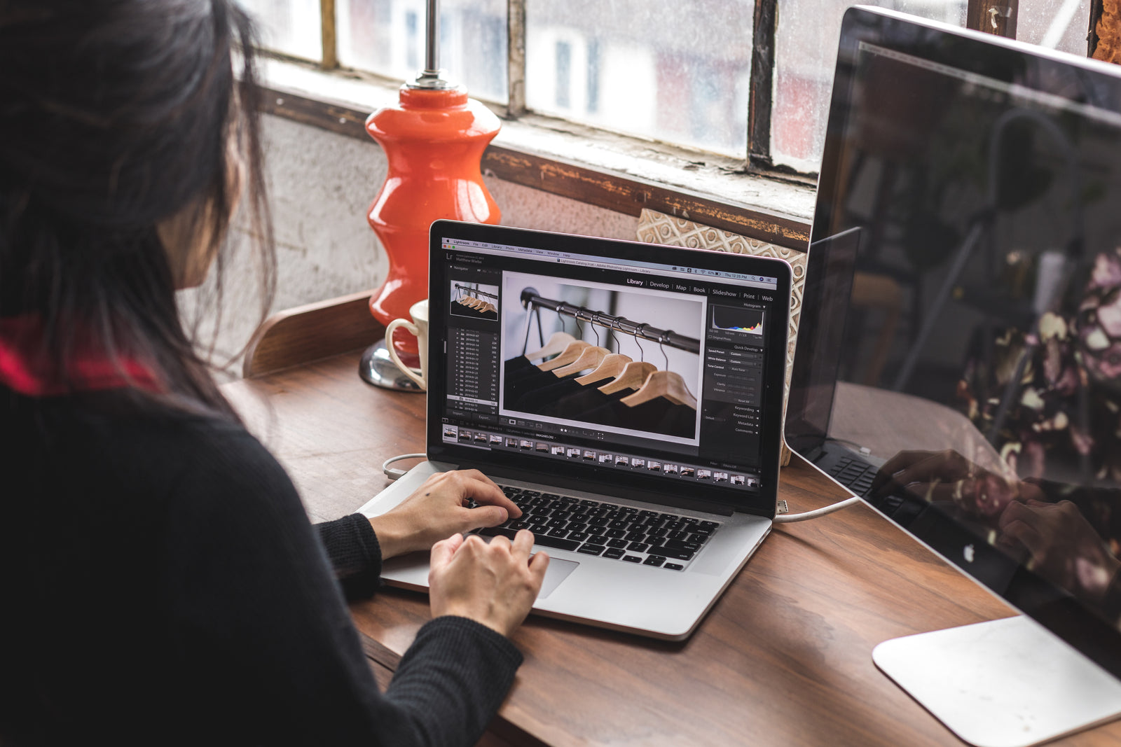 Person editing photos of clothes on a laptop